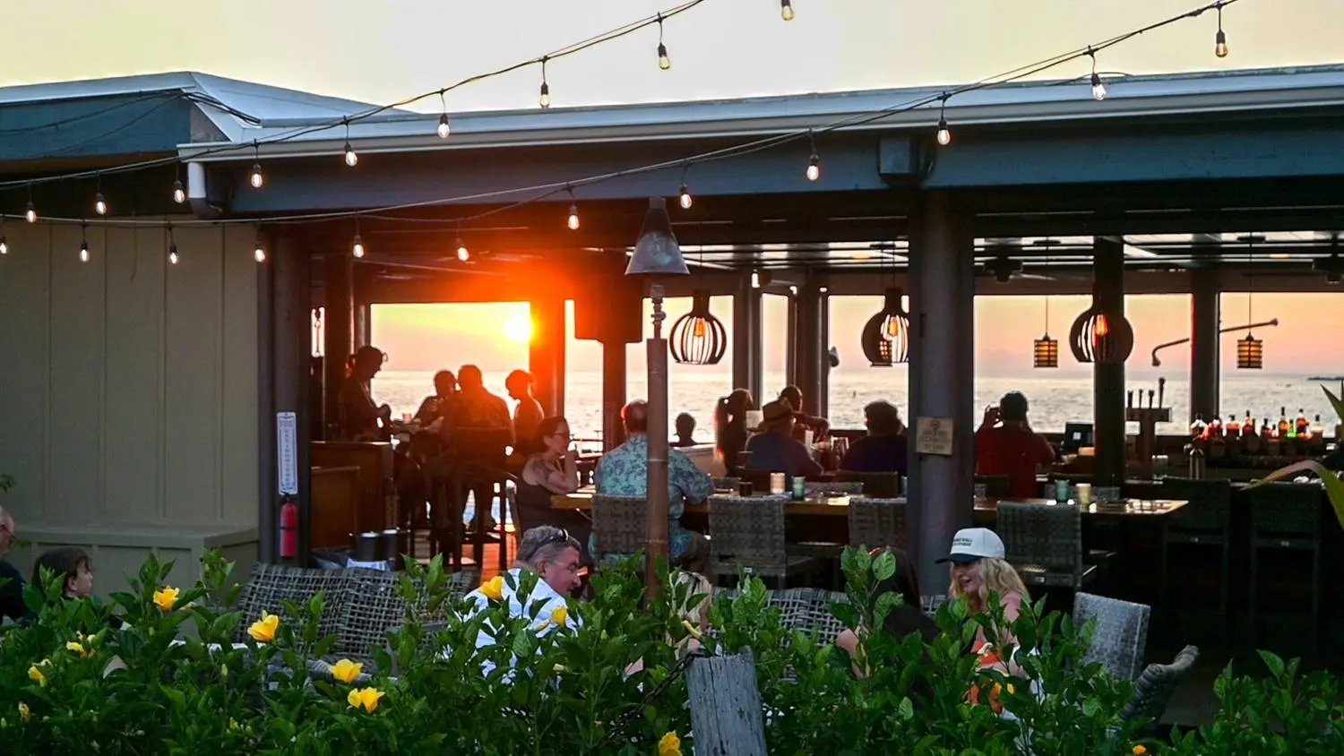 Two guests toasting cocktails over the water at hBAR