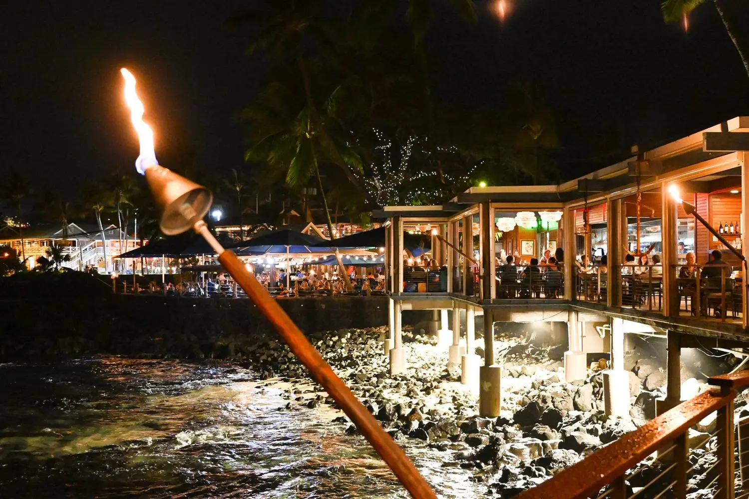 Huggo's lit up at night from the shoreline